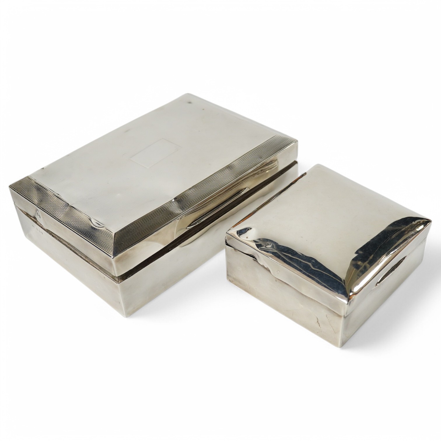 Two silver engraved cigarette boxes (a.f.). largest 16.6cm. Condition - poor